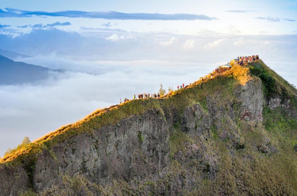 Вершина вулкана Агугнг на рассвете с высоты птичьего полёта с туристами